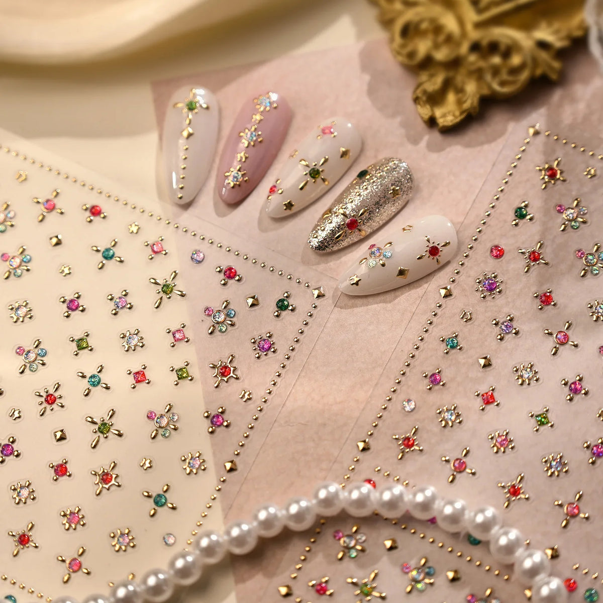 Close-up of sparkling 5D diamond nail art stickers arranged on a pink background with a pearl border.