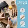 A collection of 24 essential tools for clay artists including sculpting tools, tips, and shapers laid out on a wooden surface