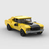 A yellow classic supercar model built from building blocks, shown in a side view.