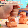 An orange capybara squeeze toy is being held by a hand, demonstrating its use for stress relief.