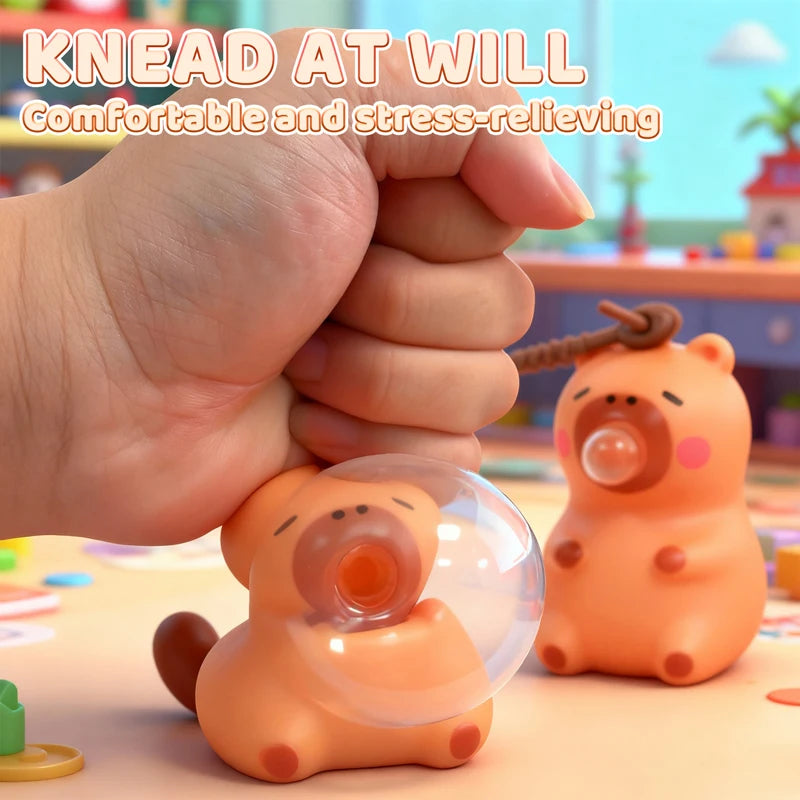 An orange capybara squeeze toy is being held by a hand, demonstrating its use for stress relief.