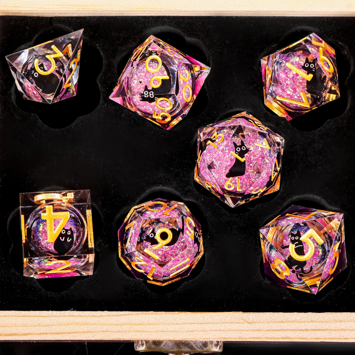 A set of liquid core cat dice in various colors and shapes displayed on a black surface.
