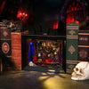 A dark, ornate wooden bookshelf insert featuring a gothic scene with LED lighting and surrounded by decorative books.