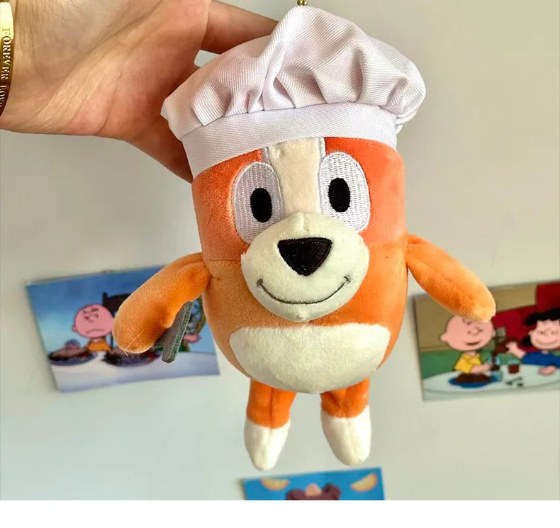 An orange and white plush toy resembling a dog wearing a white chef's hat.
