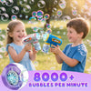 Two children are playing with an automatic bubble machine gun, creating many bubbles in a sunny outdoor setting.