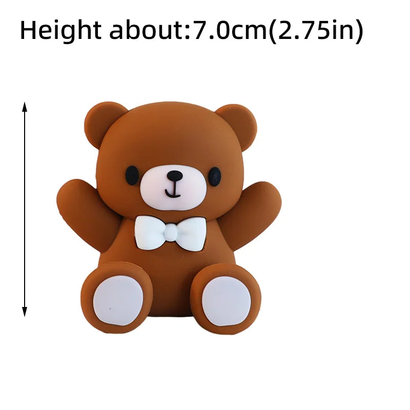 A small, round brown bear cake topper with white accents.