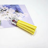A bundle of bright yellow velvet tassels with silver metal findings displayed on a purple background.