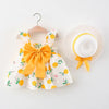 A yellow and white floral baby girl summer dress and sunhat set with bow details.