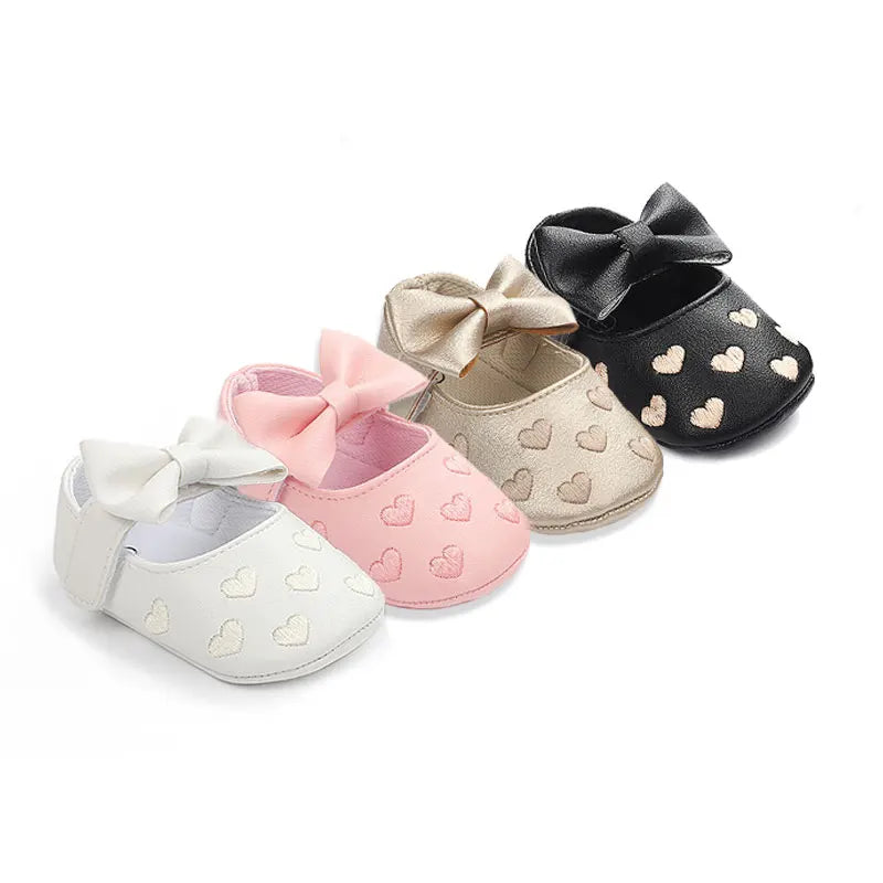 A set of three baby girl bow-knot first walker shoes in pink, beige, and black with soft anti-slip soles.