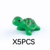 Five green plastic marine animal building blocks including a shark or turtle shape.