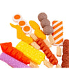 A collection of colorful toy food items including orange, yellow, and red pieces for a kids pretend play BBQ grill set.