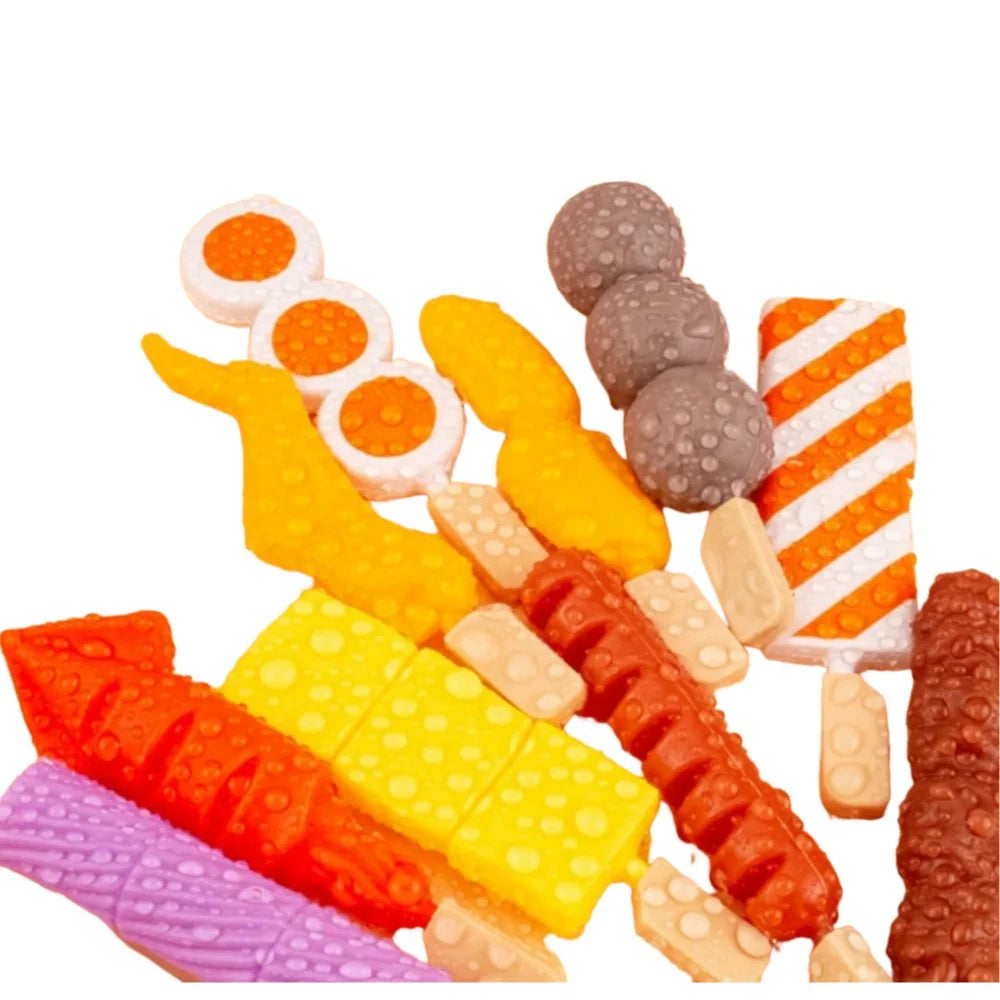 A collection of colorful toy food items including orange, yellow, and red pieces for a kids pretend play BBQ grill set.