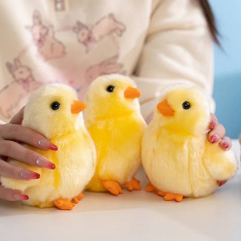 Three adorable yellow chick plush toys being held by a person against a light background.