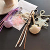 A collection of beaded keychains featuring starfish, shells, and pearls on a white card.