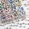 A clear plastic box filled with a variety of round ceramic flower beads in various colors and patterns for jewelry making