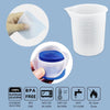 A white silicone resin mixing tool kit shown with a measuring cup and stir sticks, demonstrating its use.