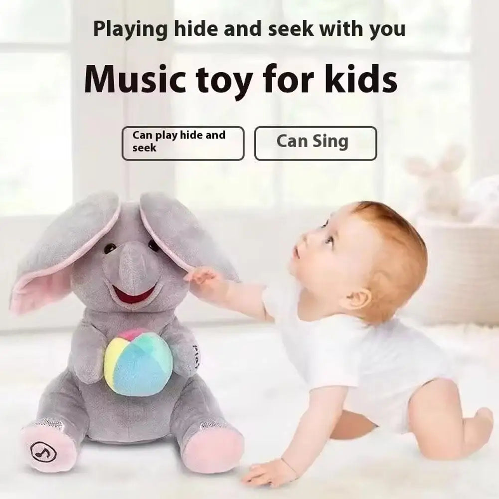 Un bébé joue à cache-cache avec une peluche d'éléphant gris pour enfants.
