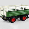 A green and white remote control tractor with a trailer is shown on a white surface.