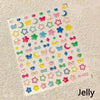 A sheet of colorful jelly nail art stickers featuring various shapes and colors like stars moons and hearts.
