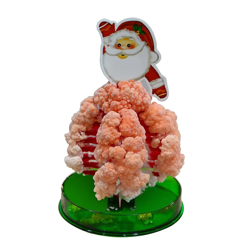 A crystal growing tree science kit featuring a Santa face decoration and a pink blooming tree on a green base.
