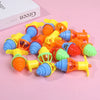 A collection of glow-in-the-dark spinning tops in various bright colors like yellow, orange, blue, and green.