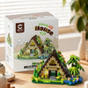 A cardboard box for a miniature forest cabin building block set featuring a house, greenhouse, and windmill.