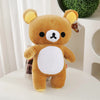 A fluffy brown Rilakkuma anime plush bear with a white chest patch sitting on a white surface.