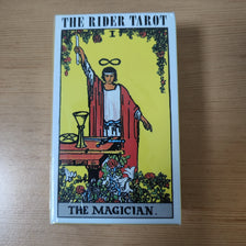 The Rider Tarot card depicting The Magician, a male figure holding a staff and an infinity symbol.