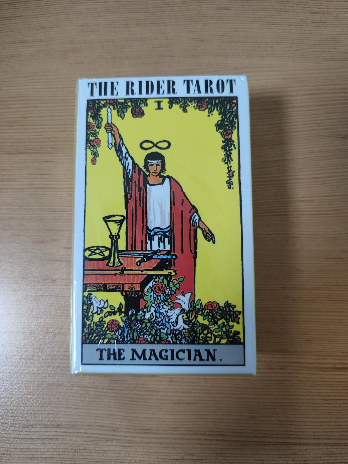 The Rider Tarot card depicting The Magician, a male figure holding a staff and an infinity symbol.