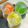 A collection of clear squishy stress balls shaped like various fruits, including oranges and lime slices, in orange, green, a