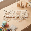 A wooden Montessori busy board for toddlers featuring various animal shapes and sensory elements on a light wood table.