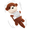 A handmade crochet otter plush toy with brown fur and white accents, featuring a tag that reads Positive Otter.