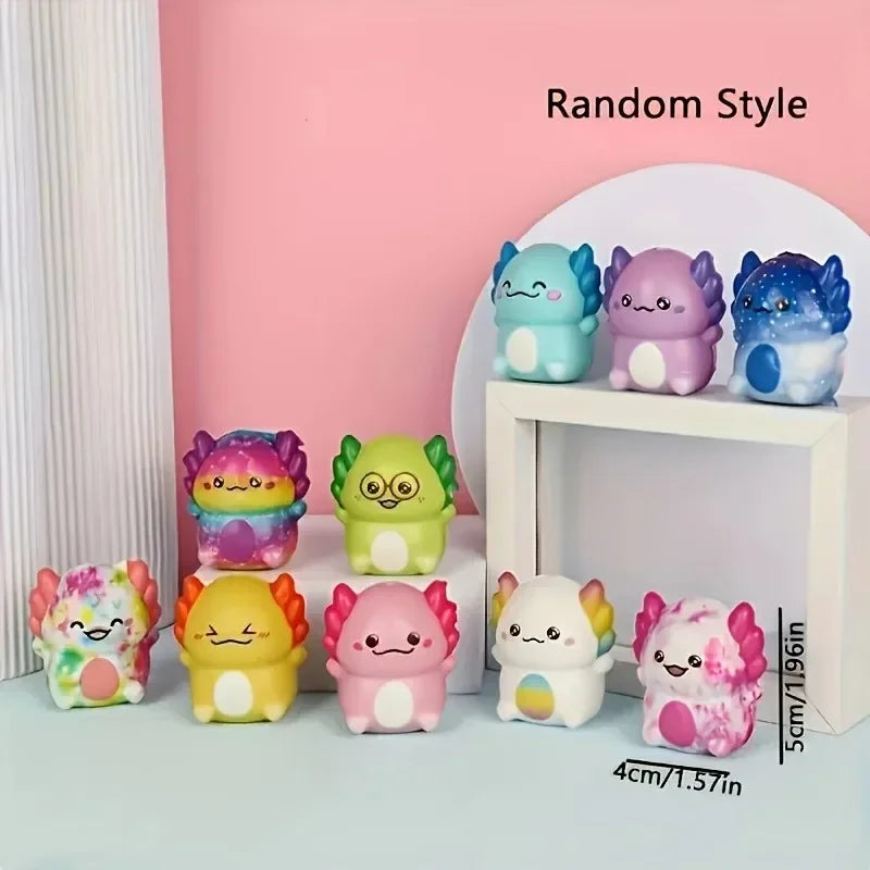 A collection of colorful squishy slow-rise stress relief toys shaped like cute newt figurines displayed on a white shelf.