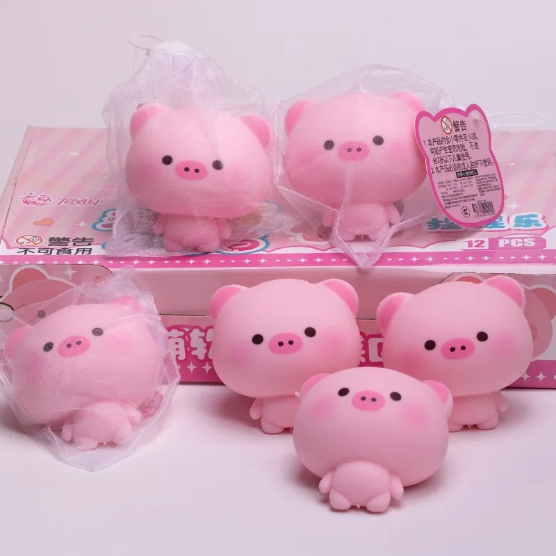 Pink squishy pig stress relief toys packaged in clear plastic bags and displayed on a box.