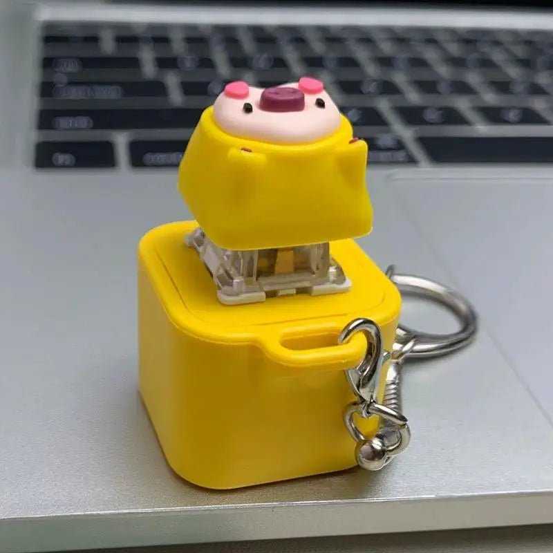 Geliger Fidget-Anhänger mit froschähnlicher Figur und rosa Akzenten.