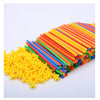 A pile of colorful interlocking building straws and connectors in various bright colors like yellow, green, orange, and blue.