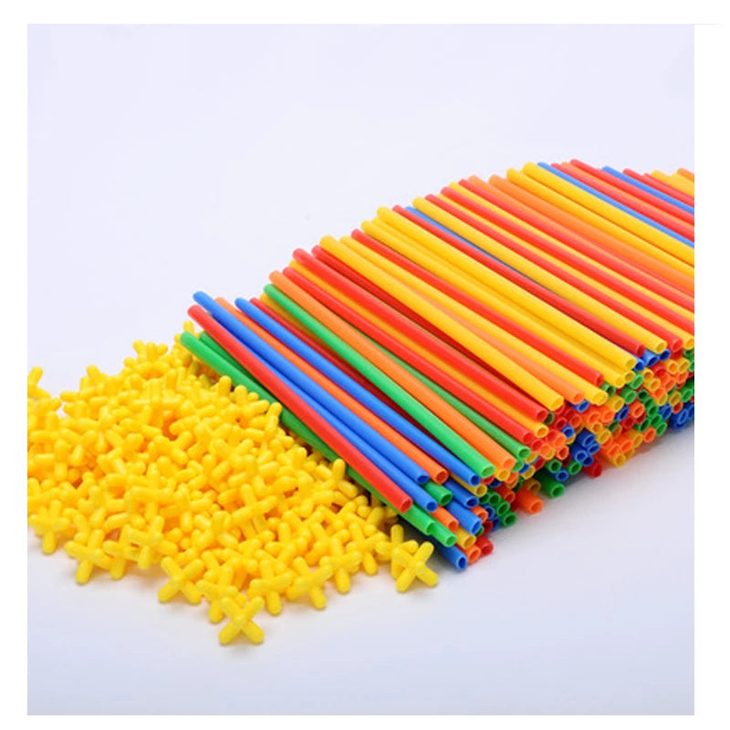 A pile of colorful interlocking building straws and connectors in various bright colors like yellow, green, orange, and blue.