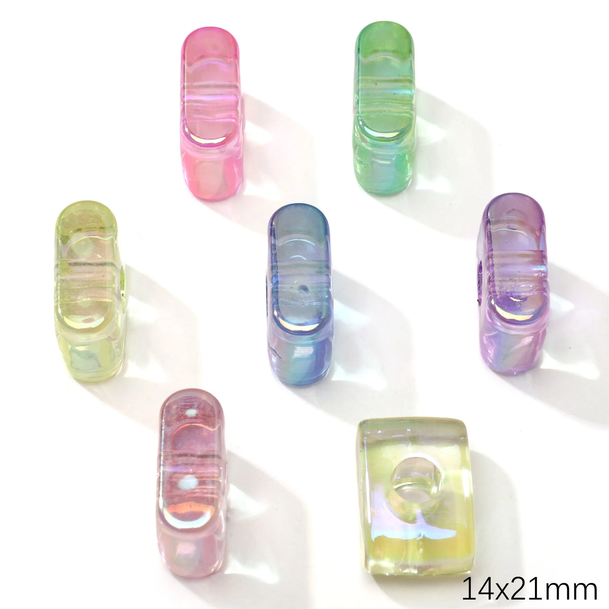 A collection of colorful, translucent acrylic alphabet beads in various shades of pink, green, and blue.