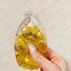 A hand holds a clear yellow bottle filled with liquid, labeled Chiboki, used as a fidget toy.