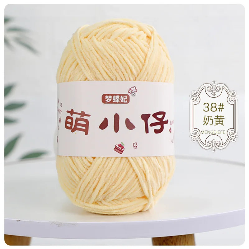 A ball of light yellow chenille yarn labeled with Chinese characters for knitting and crochet.