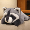 A gray and white raccoon plush toy resting on a light-colored surface.