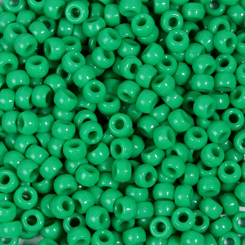 A pile of small, bright green, round pony beads for jewelry making and craft projects.