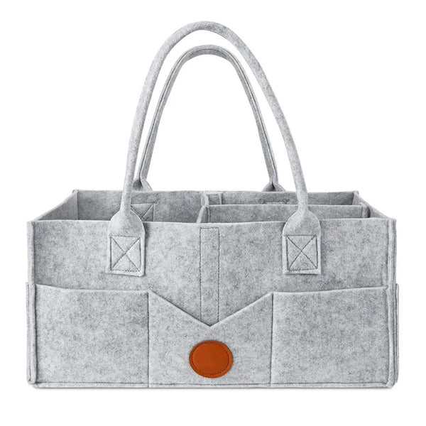 A light gray felt diaper storage bag with long handles and a flap closure.