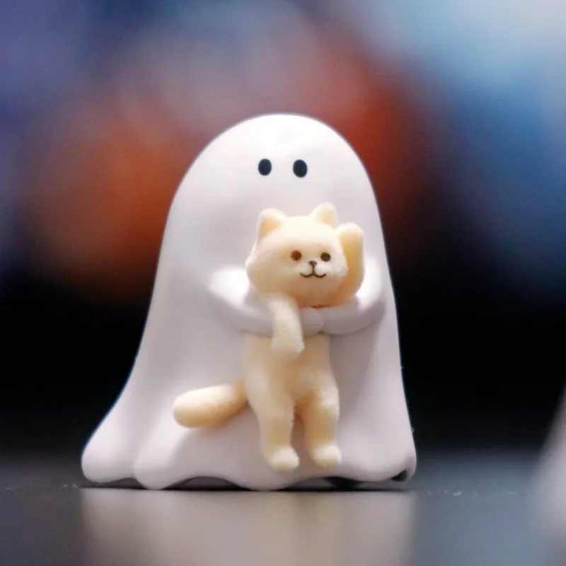 A white ghost-shaped collectible figurine of a cat is shown against a dark background.