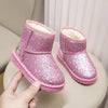 A pair of sparkly pink winter snow boots with faux fur lining resting on a light surface.