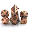 A set of premium metal polyhedral dice with a multicolor gold finish arranged on a white surface.