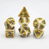 A set of polyhedral dice including a triangular die, a d20, and a d12, all with a yellow and white marbled pattern.