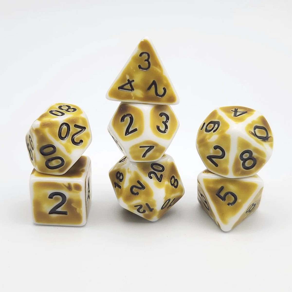 A set of polyhedral dice including a triangular die, a d20, and a d12, all with a yellow and white marbled pattern.