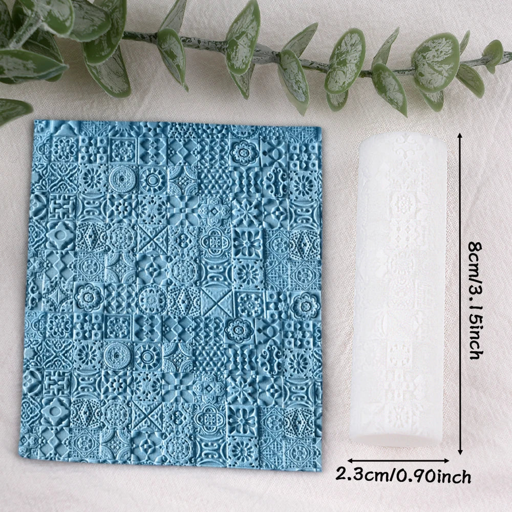 A square blue textured clay roll with floral patterns next to a white rolled paper.