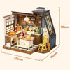 A miniature dollhouse kit featuring a cozy baking kitchen with wooden cabinets, tools, and a yellow chair.